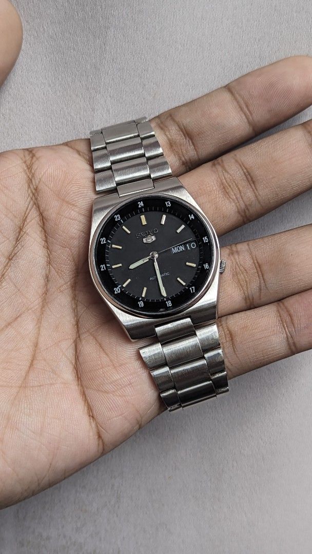Seiko 5 Automatic Stainless Steel Watch (Category: Men's Watches) located in Caloocan City. Submitted by bimgol (Listing ID 1467483044, Image 1). Description: - Brand: Seiko 5 Automatic Watch - Dial: Classic black with day and date display at 3 o'clock - Markers: Outer track featuring 24-hour markers - Movement: Automatic (no battery required) - Bracelet/Case: Brushed silver stainless steel with minor signs of wear - Condition: Good, working perf