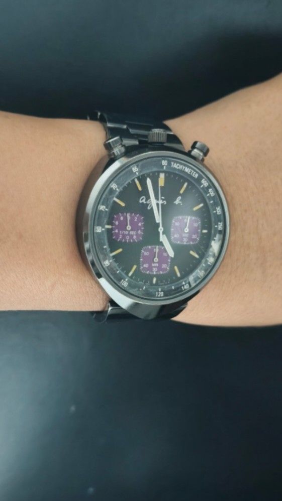 Seiko Agnes b.bullhead Chronograph Tachymeter Bezel Unisex Watch Japan (Category: Luxury Watches) located in Taguig. Submitted by mercyeugen28914 (Listing ID 1466291351, Image 2). Description: - Brand/Model: Preloved Agnes b. Watch Seiko - Material: Black stainless steel case and matching metal bracelet with signed clasp - Dial: Dark dial accented with striking purple subdials - Features: Tachymeter bezel and three side pushers - Condition: Shows