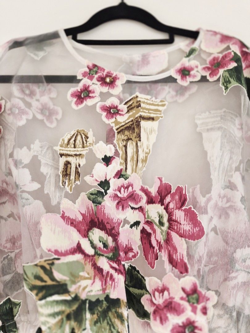 Sheer Floral Longsleeves Top (Category: Blouses) located in Manila. Submitted by unknowncloset (Listing ID 1467448820, Image 2). Description: - Sheer long-sleeve blouse with pink floral prints and architectural column graphics - Versatile design: can be worn frontwards or backwards - Cropped length with gathered elastic hem and cuffs - Made from a lightweight, breathable fabric - Features delicate floral appliques throughout for an extra touch of