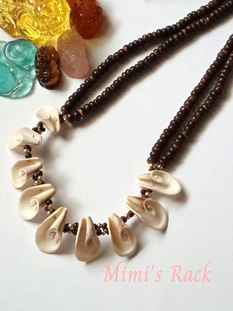 Shell and Wood Necklace (Category: Necklaces) located in Taguig. Submitted by mimisrack (Listing ID 1467436988, Image 2). Description: 🤎🐚A unique statement necklace featuring natural-looking dark wooden beads paired with beautiful cream and beige carved shell pendants. ✨ The intricate spiral designs add an artistic, earthy charm, while the gold-tone accent beads give it a subtle touch of elegance. 🧿 wood beads: 5mm 🧿 shell size: 12mm 🧿 neckl
