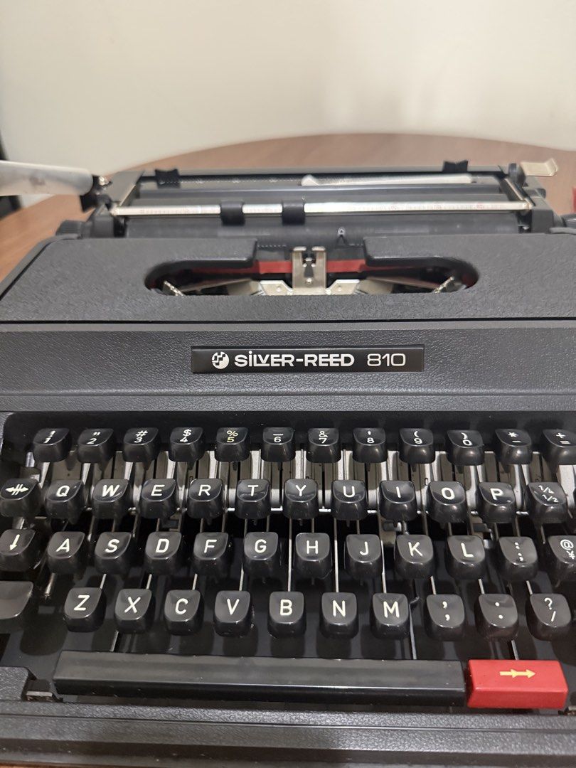 Silver-Reed 810 Typewriter (Category: Office & Business Technology) located in Taguig. Submitted by baghabitmnl (Listing ID 1466477336, Image 2). Description: - Brand/Model: Silver-Reed 810 Manual Typewriter - Color: Classic black with white lettering - Keyboard: Standard QWERTY layout - Condition: Fully functional, well-maintained mechanical parts - Inclusions: Matching black hard protective case with carrying handle - Perfect for: Creative writ