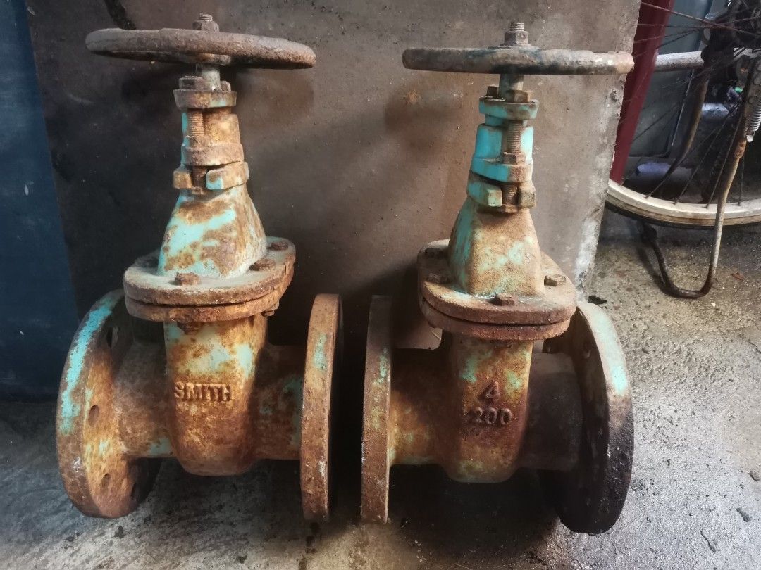 Smith Industrial Flanged Gate Valves (Category: Industrial Equipment) located in Caloocan City. Submitted by happystone.af80b1 (Listing ID 1467369727, Image 1). Description: - Brand: Smith - Quantity: 2 heavy-duty industrial gate valves - Material: Solid cast metal with blue-green painted body - Condition: Heavy surface rust from storage, ideal for restoration - Features: Manual top handwheel operation, flanged ends with bolt holes - Aesthetic: S