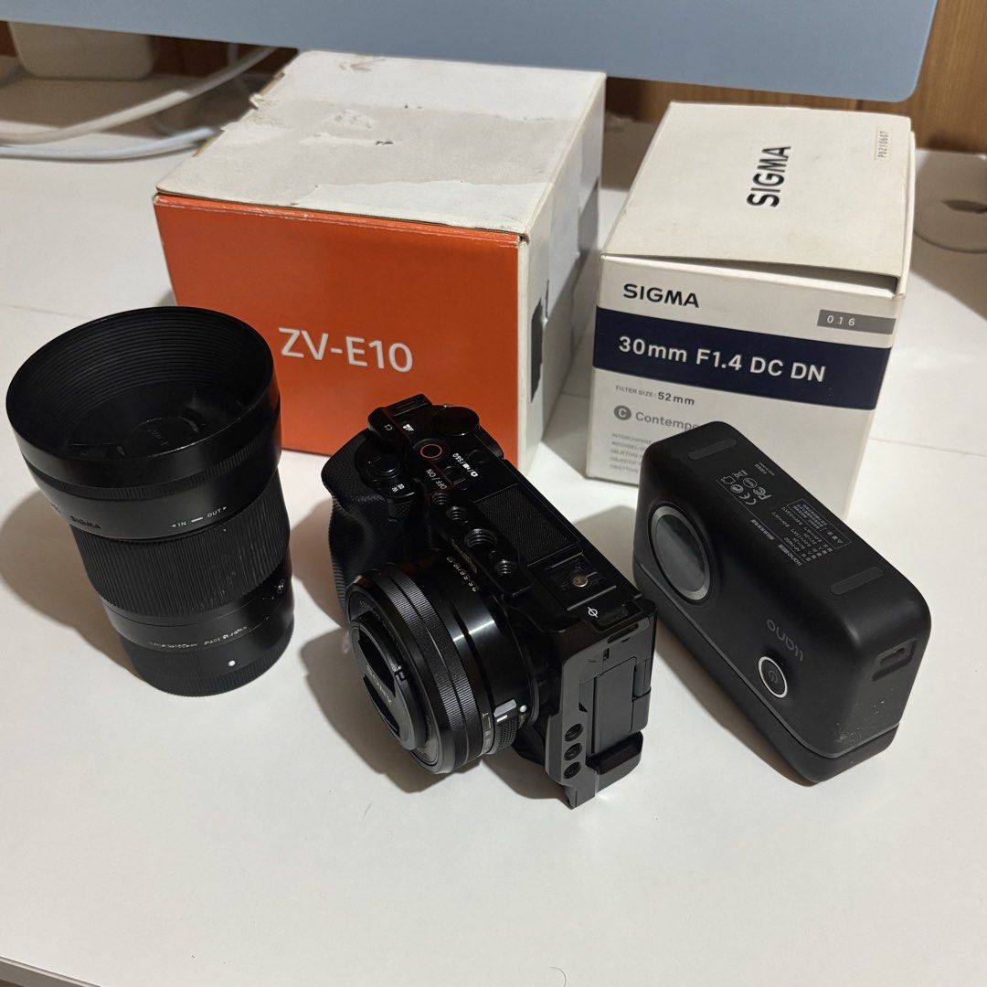 Sony ZV-E10 Camera with Sigma Lens and Accessories (Category: Cameras) located in Apalit. Submitted by brentarcivi-52917 (Listing ID 1467577607, Image 1). Description: For sale ZV-E10 - complete with box & accesories - slightly used/under warranty Inclusion: -Smallrig Cage -Sony 15-50 Kitlens -Sigma 30mm 1.4 (with box) -Llano Battery Chager - 1 orig / 2 rav power battery (total 3 batts) -orig sony strap Price: 40.