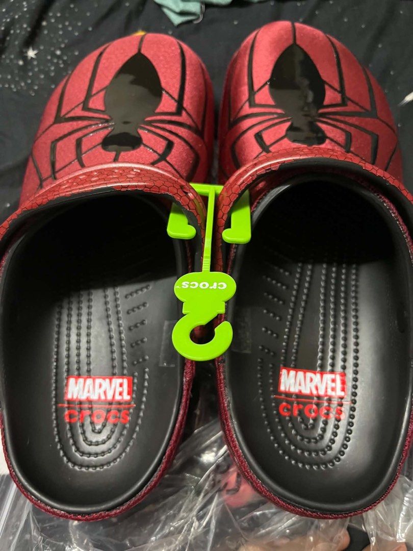 Spider-Man Crocs Clogs Size M10 W12 (Category: Slippers & Slides) located in Quezon City. Submitted by fresh_sneaks (Listing ID 1467373497, Image 2). Description: - Brand: Marvel x Crocs Spider-Man Clogs - Colorway: Red and black with glossy spider graphic - Size: Men's 10 / Women's 12 - Details: Textured honeycomb strap, special Spider-Man pivot rivet buttons, black footbed with Marvel logo - Condition: Brand new with green hanger tag attached, 