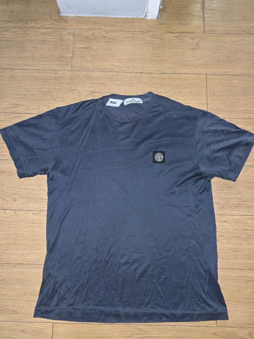 Stone Island Logo Patch T-Shirt Dark Grey Size M (Category: Tshirts & Polo Shirts ) located in Manila. Submitted by dunnohihi (Listing ID 1467368183, Image 1). Description: Stone Island crewneck t-shirt in dark grey. Features the signature compass patch embroidered on the chest. Size medium tag attached inside near the collar. Includes certilogo label showing authentication code CLG 195 220 169 592 with QR code. Soft cotton jersey fabric with sho