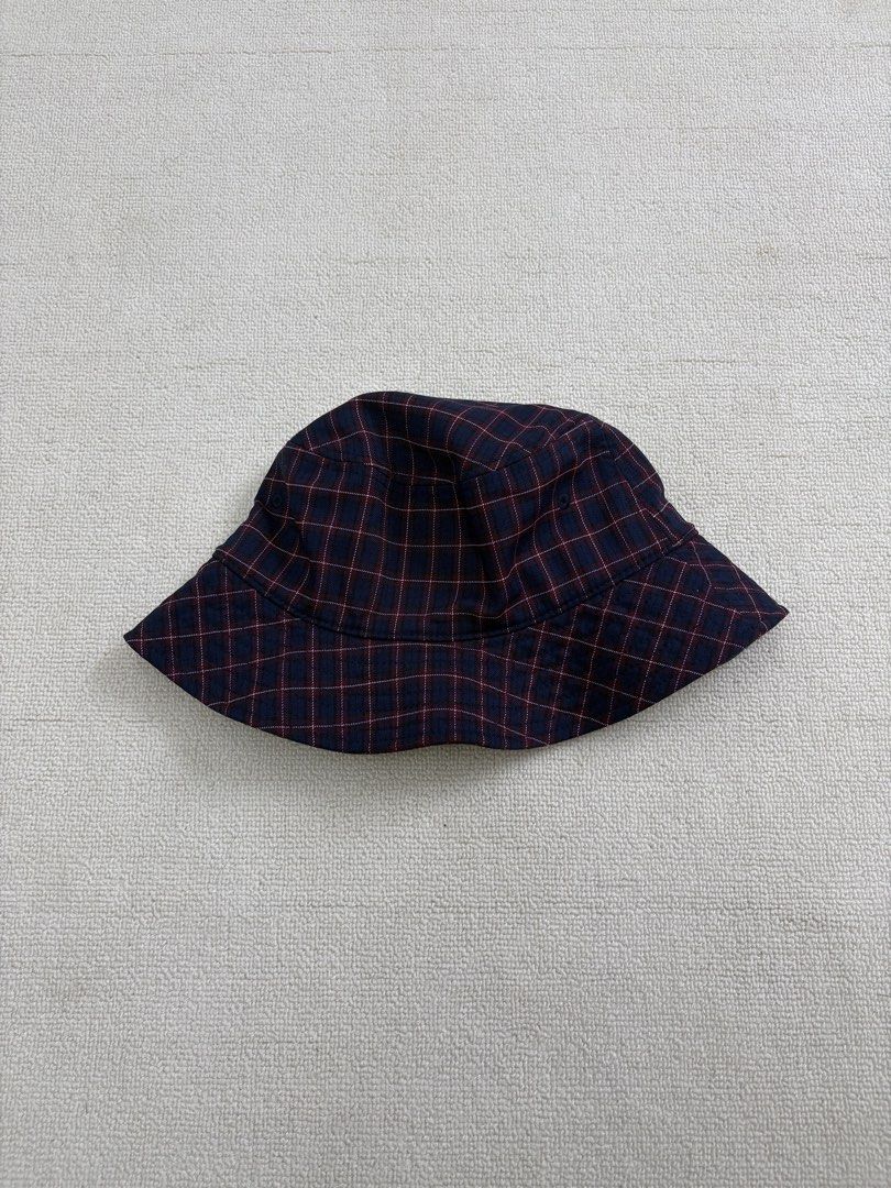 Stussy Plaid Bucket Hat (Category: Caps & Hats) located in Manila. Submitted by porma.market (Listing ID 1467404194, Image 3). Description: - Brand: Stussy - Design: Navy and burgundy plaid - Logo: Iconic embroidered white signature logo on front - Interior: Black lining with official branded inner tag - Fit: Structured brim, comfortable for everyday wear - Style: Classic streetwear essential.