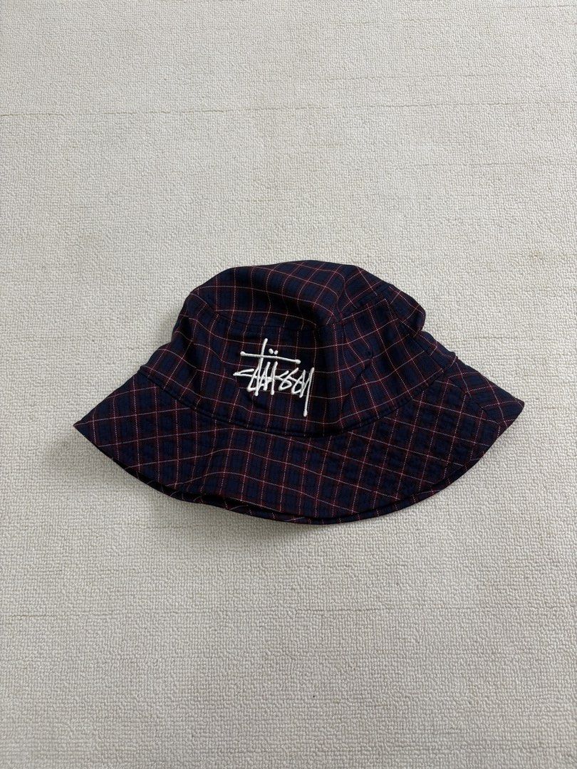 Stussy Plaid Bucket Hat (Category: Caps & Hats) located in Manila. Submitted by porma.market (Listing ID 1467404194, Image 2). Description: - Brand: Stussy - Design: Navy and burgundy plaid - Logo: Iconic embroidered white signature logo on front - Interior: Black lining with official branded inner tag - Fit: Structured brim, comfortable for everyday wear - Style: Classic streetwear essential.