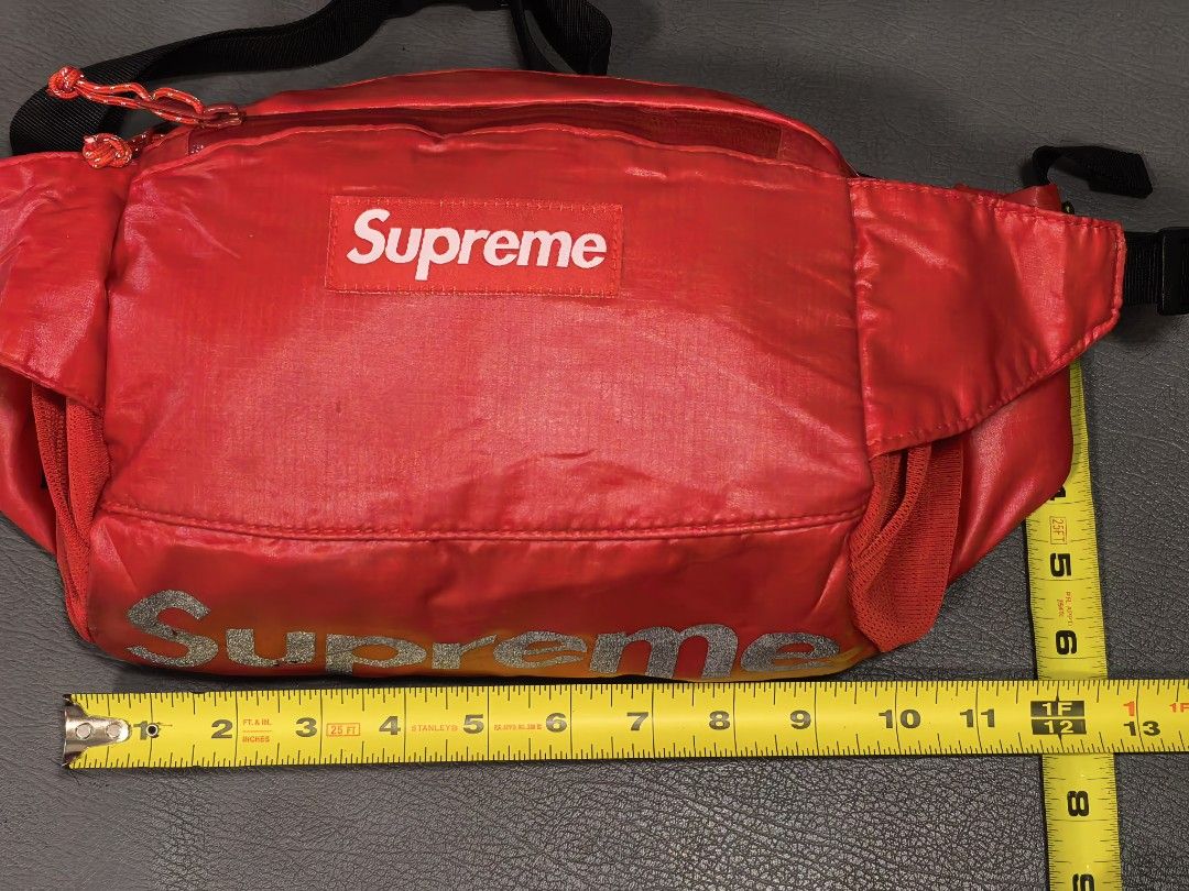 Supreme Red Waist Bag (Category: Belt bags, Clutches and Pouches) located in Cagayan de Oro. Submitted by pootx (Listing ID 1467518410, Image 2). Description: - Authentic Supreme waist bag in striking bright red - Features the classic box logo on the front and reflective branding along the bottom - Multiple zipped compartments equipped with easy-pull toggles - Secure interior lined in red fabric with an extra slip pocket - Adjustable black straps