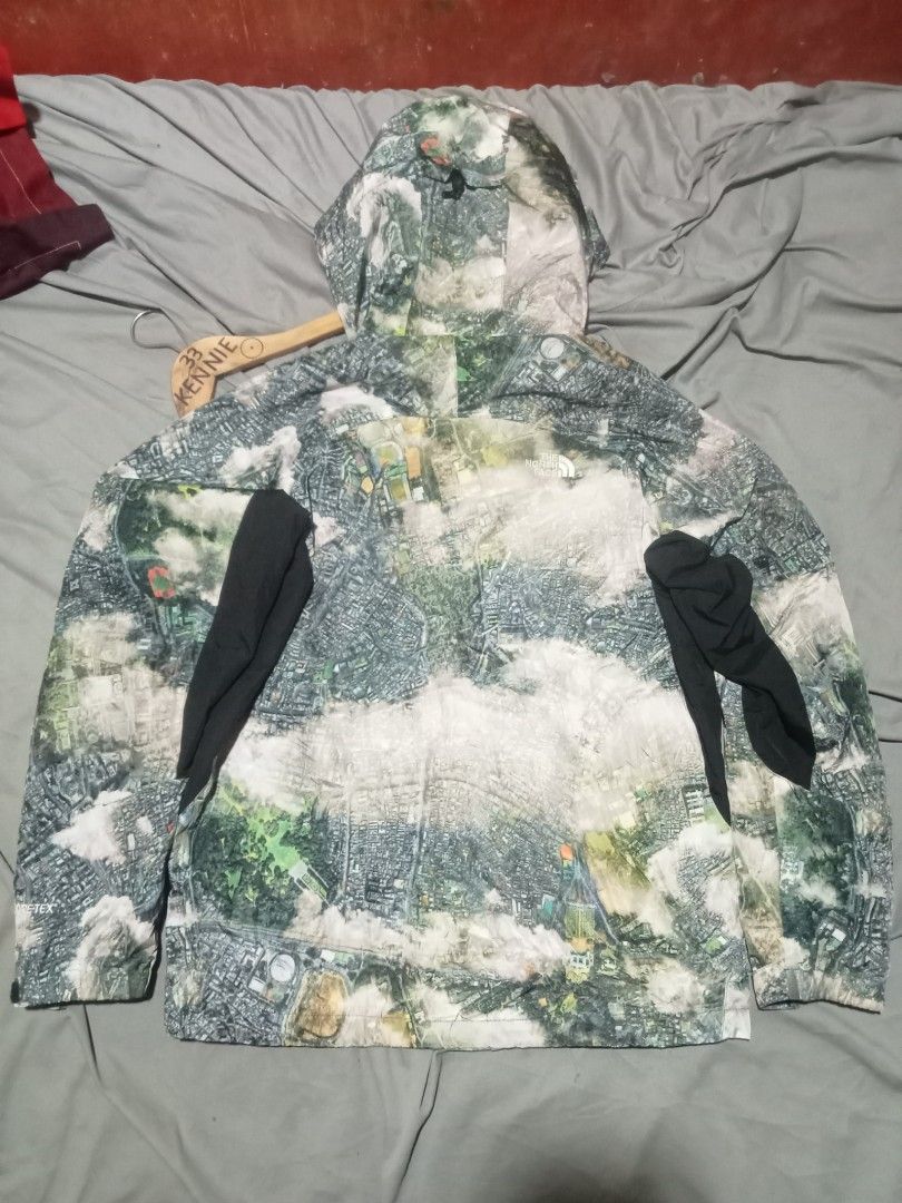 Supreme The North Face Aerial Tapestry Jacket (Category: Coats, Jackets and Outerwear) located in Sagay. Submitted by kennie_3377 (Listing ID 1467417395, Image 2). Description: Supreme and The North Face collaboration jacket. Aerial map city print across the entire piece. Size small. Zipper pockets on the front. Double branding patches on the sleeve and inside collar. Tag shows model number NP618677. Inner lining has a silver dot pattern..