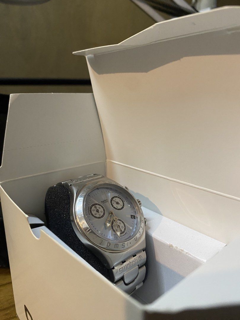 Swatch Chrono Watch (Category: Men's Watches) located in Manila. Submitted by jm.alf (Listing ID 1467447227, Image 1). Description: - Authentic silver Swatch chronograph watch with a sleek metal bracelet strap - Clean white dial featuring three sub-dials and a convenient date display - Swatch branding neatly engraved on the clasp - Battery-operated and ready to wear - Comes complete with the original white packaging box and black foam holder.