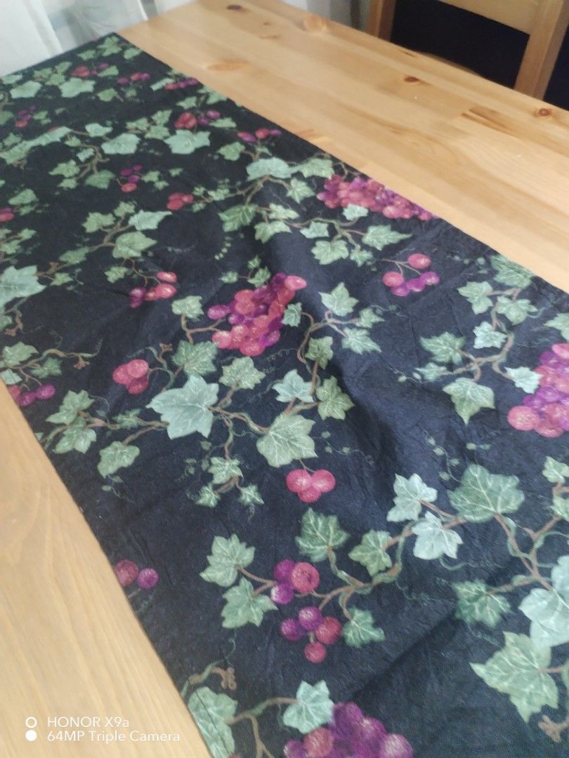 Table Runner ( missing one Palawit) (Category: Towels, Napkins & Holders) located in Muntinlupa City. Submitted by arciagamaryann68 (Listing ID 1467455119, Image 2). Description: - Color: Black base with purple grape clusters and green vine leaves - Feature: Elegant purple tassels on both ends for a classy finish - Material: Fabric table runner, great for dining setup or coffee tables - Condition: Excellent pre-loved condition, well-maintained - 