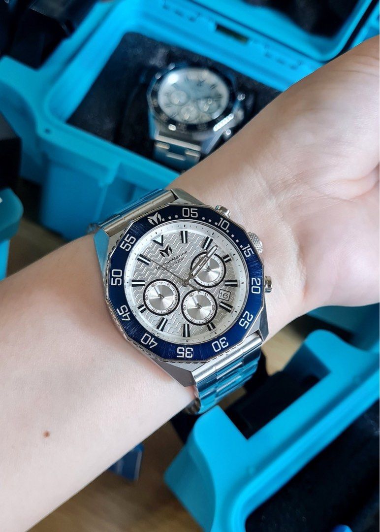 TechnoMarine Chronograph Watch Silver Blue Dial Steel (Category: Men's Watches) located in Caloocan City. Submitted by mode.manila (Listing ID 1467372559, Image 2). Description: - Brand: TechnoMarine Chronograph Watch - Condition: Brand new, still wrapped in protective plastic film - Dial: Silver wave-pattern with multiple subdials and date window at 4 o'clock - Bezel: Striking blue rotating bezel - Material: Durable stainless steel case and brac