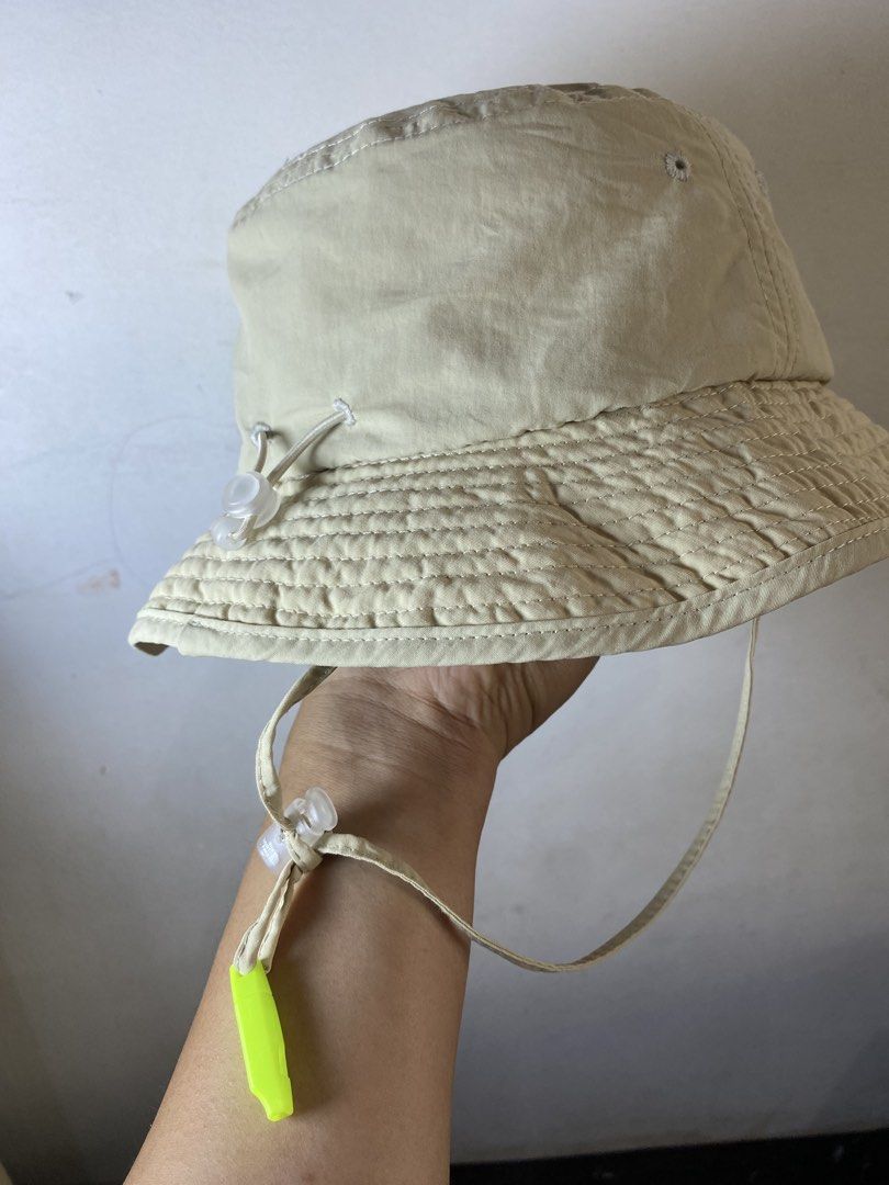 The North Face Beige Explorer Bucket Hat Size 56CM (Category: Caps & Hats) located in Manila. Submitted by kennyfranc39614 (Listing ID 1467516415, Image 3). Description: - Brand: The North Face - Color: Beige exterior with a bright yellow inner brim - Size: 56CM (marked on tag) - Fit: Adjustable toggle cord at the back for a custom fit - Extra Feature: Includes a chin strap with a detachable neon green safety whistle - Interior: Breathable mesh l