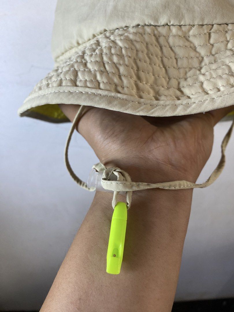 The North Face Beige Explorer Bucket Hat Size 56CM (Category: Caps & Hats) located in Manila. Submitted by kennyfranc39614 (Listing ID 1467516415, Image 2). Description: - Brand: The North Face - Color: Beige exterior with a bright yellow inner brim - Size: 56CM (marked on tag) - Fit: Adjustable toggle cord at the back for a custom fit - Extra Feature: Includes a chin strap with a detachable neon green safety whistle - Interior: Breathable mesh l