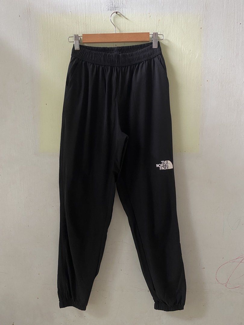 The North Face Black Jogger Pants (Category: Joggers) located in Pandi. Submitted by nasya_thrift_collection2023 (Listing ID 1467415247, Image 1). Description: - Brand: The North Face - Color: Black with white logo - Size: US Large / Asia XL - Fit & Comfort: Lightweight material, elastic waistband with drawstring, and ribbed ankle cuffs - Storage: Convenient zip pocket at the back - Origin: Made in Vietnam - Condition: Brand new / Excellent quali