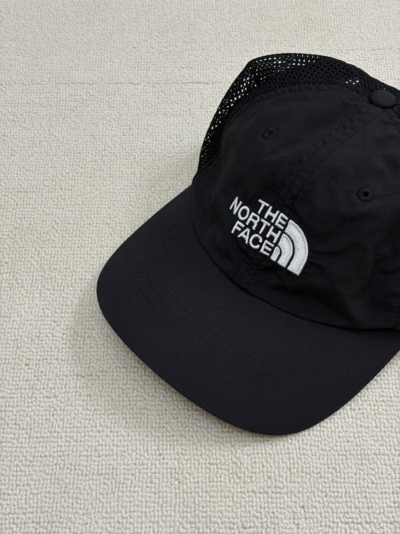 The North Face Black Mesh Trucker Cap Hat (Category: Caps & Hats) located in Manila. Submitted by porma.market (Listing ID 1467404033, Image 1). Description: - Brand: The North Face - Color: Black with white embroidered logo - Material: Breathable mesh panels for cooling - Closure: Adjustable strapback with branded interior taping - Size: One size fits most - Condition: Clean inside and out.