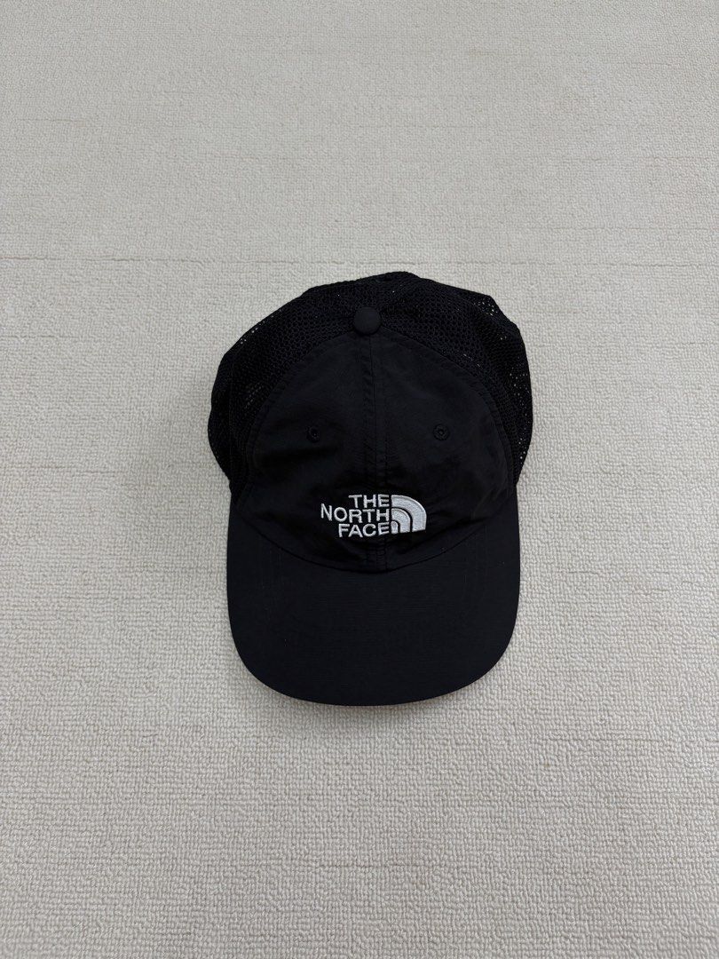 The North Face Black Mesh Trucker Cap Hat (Category: Caps & Hats) located in Manila. Submitted by porma.market (Listing ID 1467404033, Image 2). Description: - Brand: The North Face - Color: Black with white embroidered logo - Material: Breathable mesh panels for cooling - Closure: Adjustable strapback with branded interior taping - Size: One size fits most - Condition: Clean inside and out.