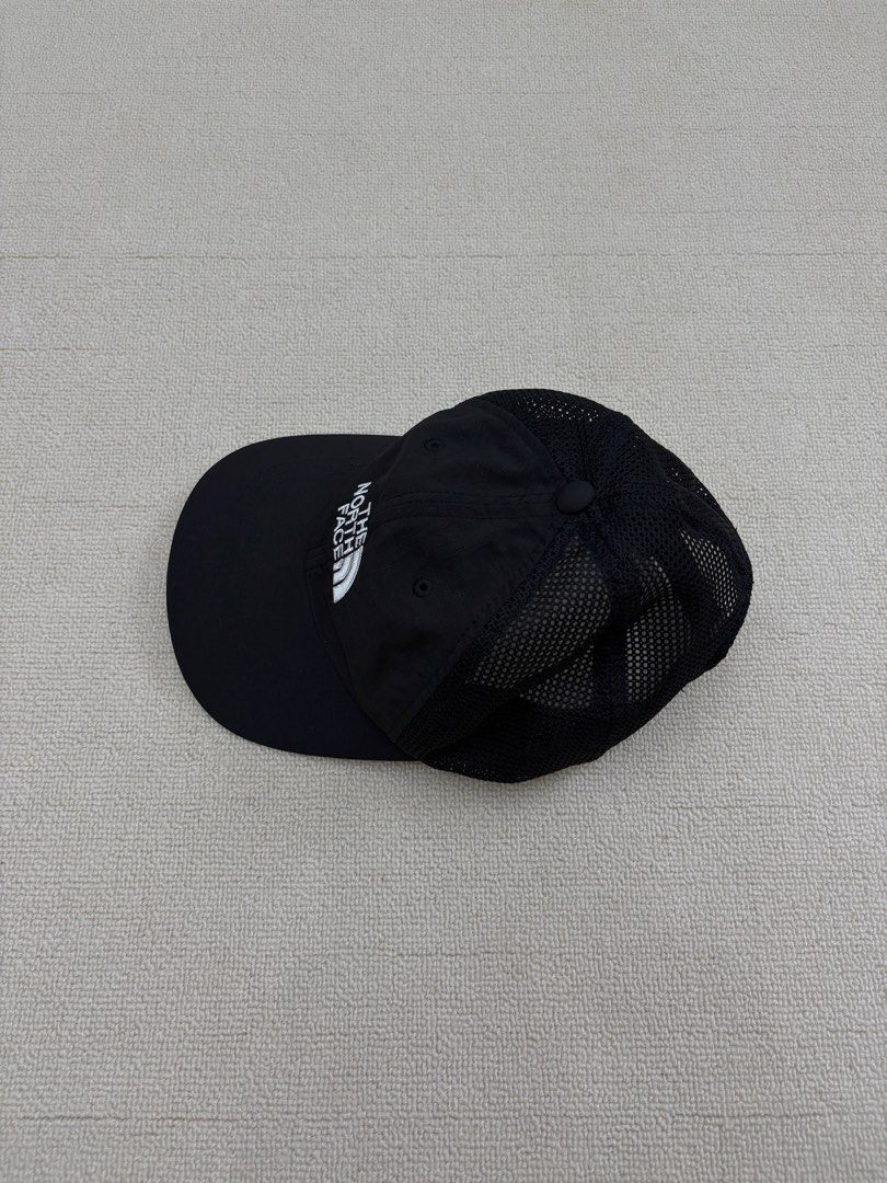 The North Face Black Mesh Trucker Cap Hat (Category: Caps & Hats) located in Manila. Submitted by porma.market (Listing ID 1467404033, Image 3). Description: - Brand: The North Face - Color: Black with white embroidered logo - Material: Breathable mesh panels for cooling - Closure: Adjustable strapback with branded interior taping - Size: One size fits most - Condition: Clean inside and out.