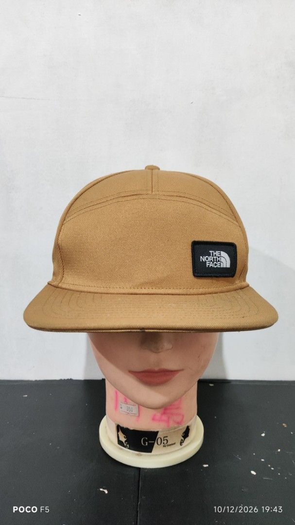 The North Face Brown Snapback Cap (Category: Caps & Hats) located in Quezon City. Submitted by ralphralph (Listing ID 1467498995, Image 1). Description: - Brand: The North Face - Style: Classic 5-panel snapback cap with a flat brim - Color: Brown - Details: Woven TNF logo patch on the front right - Fit: Adjustable plastic snap closure in the back - Condition: Clean fabric, sturdy construction, ready to wear.