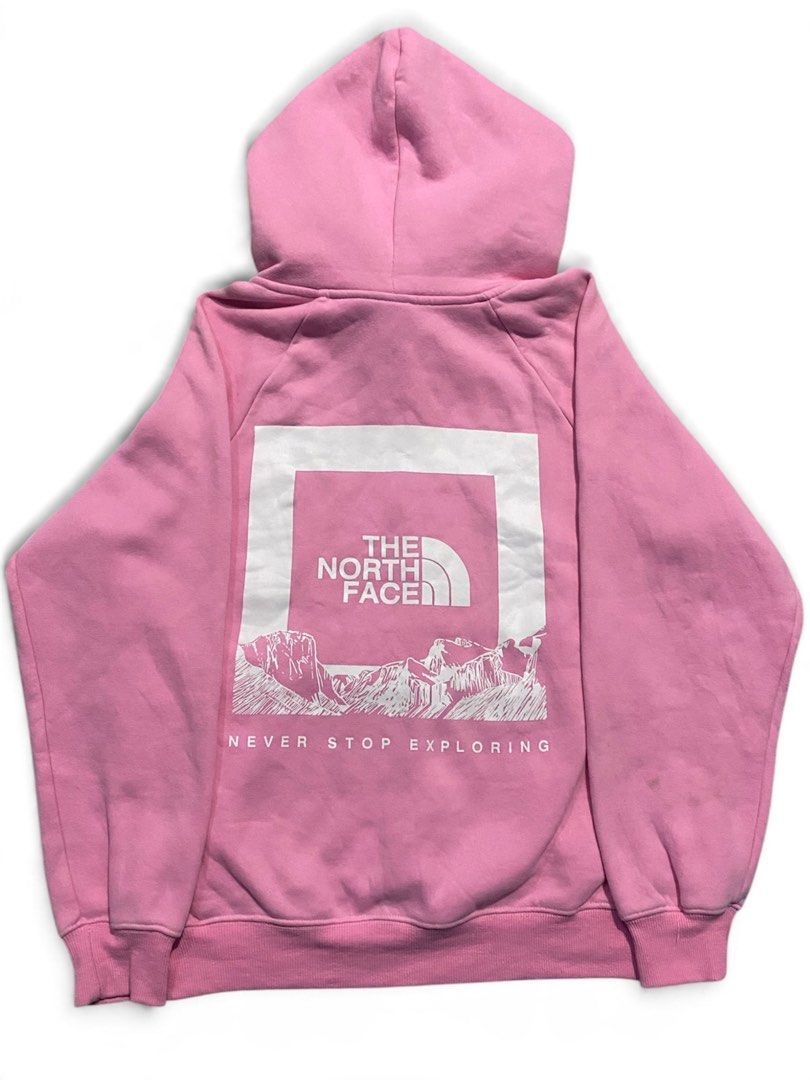 The North Face Pink Graphic Pullover Hoodie (Category: Coats, Jackets and Outerwear) located in Manila. Submitted by jerms.thriftah (Listing ID 1467399566, Image 1). Description: - Brand: The North Face - Color: Pink with white chest logo - Design: Large mountain graphic and "Never Stop Exploring" text on the back - Features: Adjustable braided drawstrings, kangaroo pocket, and soft fleece lining - Fit: Standard fit - Condition: Excellent, pre-lo
