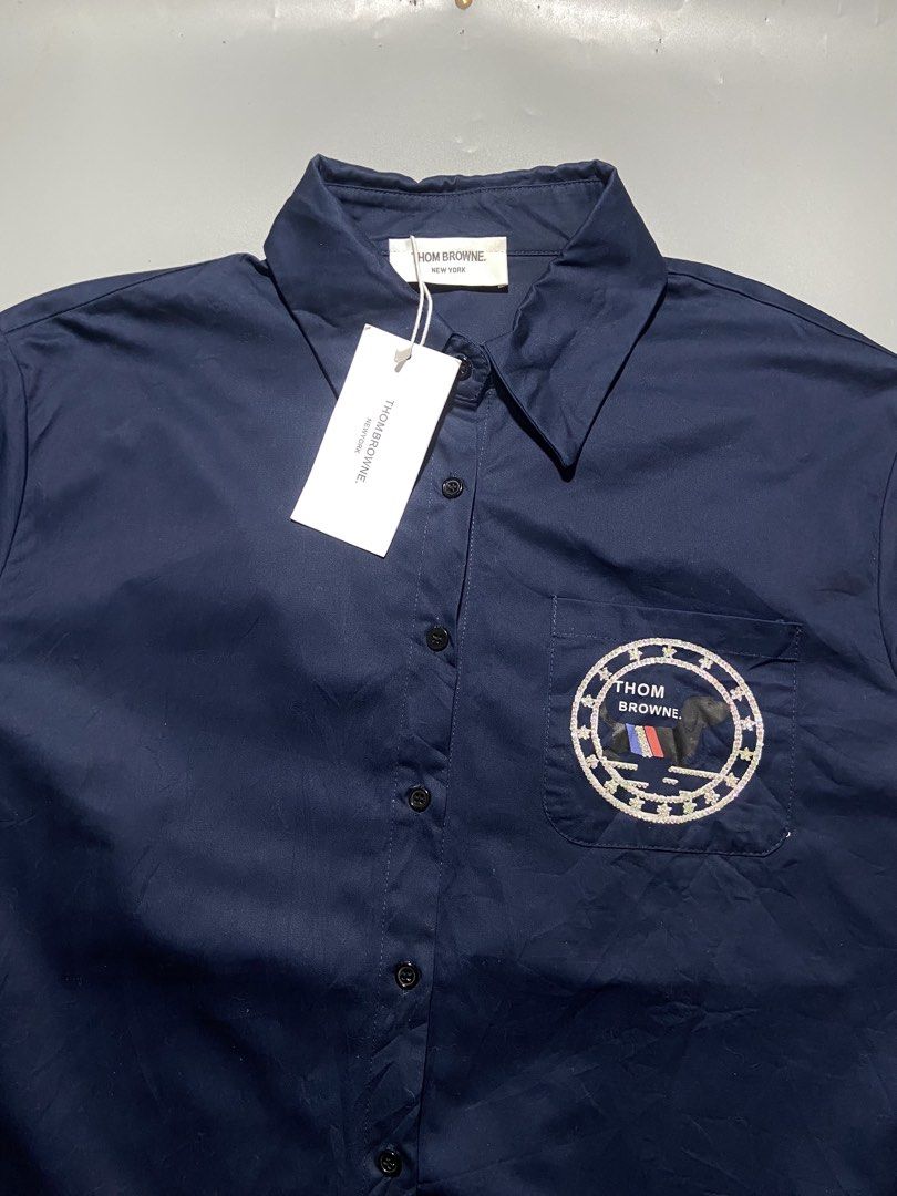 Thom Browne New York Navy Button Up Shirt (Category: Formal Shirts) located in Taguig. Submitted by lva.ph (Listing ID 1467509633, Image 3). Description: THOM BROWNE W-22.5 L-26 NO ISSUE 9/10 COLOR RATE TAGUIG CITY LOC Brand: Thom Browne New York - Color: Dark navy blue - Style: Long sleeve button-up shirt with classic collar and front button closure - Details: Signature white four-bar stripe on the left sleeve - Unique Embellishments: Circular e