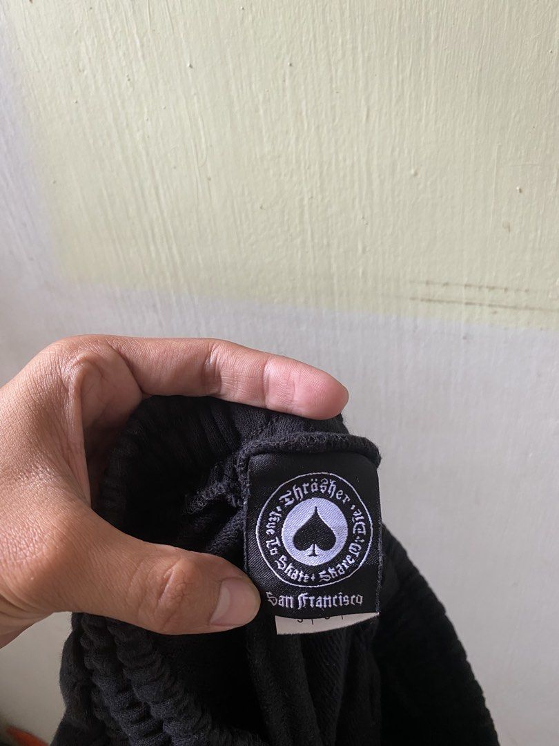Thrasher Black Track Sweatpants Size S (Category: Joggers) located in Pandi. Submitted by nasya_thrift_collection2023 (Listing ID 1467416427, Image 2). Description: - Brand: Thrasher (Manufactured by Gildan Activewear) - Size: Men's Small (Regular Fit) - Color: Black with white logo tape down the leg - Material: 100% Cotton for maximum comfort - Features: Elastic waistband with adjustable drawstring and ribbed ankle cuffs - Condition: Excellent /