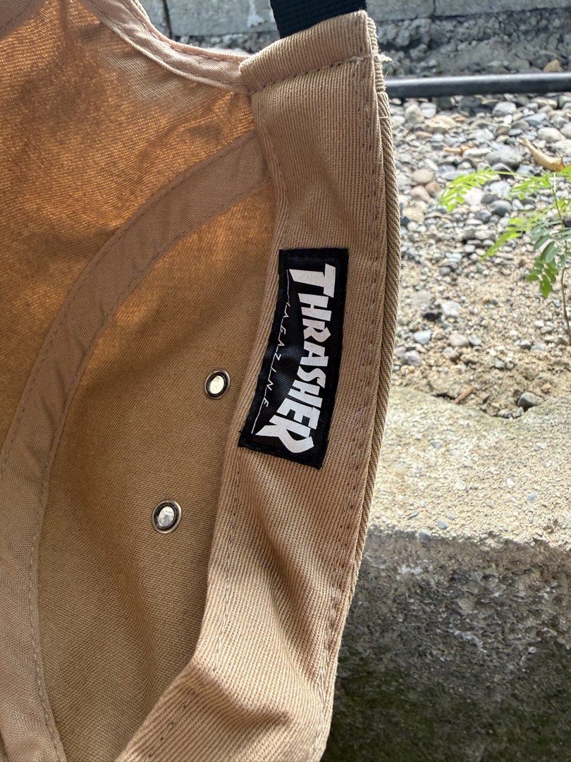 Thrasher Magazine 5-Panel Snapback Hat Tan (Category: Caps & Hats) located in Burgos, Ilocos Norte. Submitted by copthrift (Listing ID 1467371599, Image 2). Description: - Brand: Thrasher Magazine (The Classics by Yupoong) - Style: 5-panel flat brim snapback cap - Color: Tan - Details: Embroidered diamond logo patch on front, original sticker still on brim - Material: 100% cotton, made in Vietnam - Fit: Adjustable strap closure with side metal ey