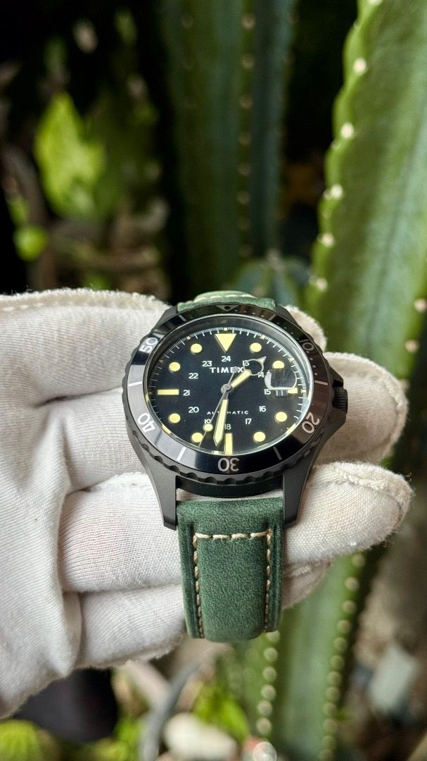 Timex Navi XL Automatic Watch Black Dial Green Strap (Category: Men's Watches) located in Manila. Submitted by junjun12356 (Listing ID 1467575507, Image 2). Description: - Model: Timex Navi XL Automatic Watch - Dial: Black with striking yellow markers and hands - Features: Rotating bezel, date window with a magnifier at 3 o'clock - Case: Dark metal with an exhibition caseback (protective sticker still attached) - Strap: Green leather with contras