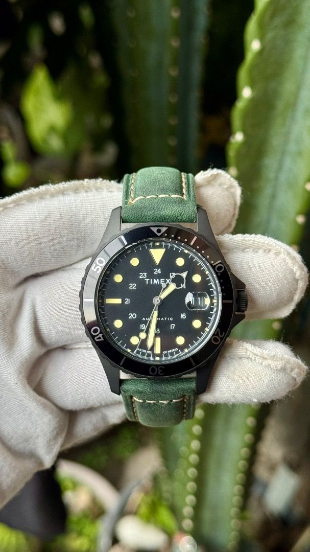 Timex Navi XL Automatic Watch Black Dial Green Strap (Category: Men's Watches) located in Manila. Submitted by junjun12356 (Listing ID 1467575507, Image 1). Description: - Model: Timex Navi XL Automatic Watch - Dial: Black with striking yellow markers and hands - Features: Rotating bezel, date window with a magnifier at 3 o'clock - Case: Dark metal with an exhibition caseback (protective sticker still attached) - Strap: Green leather with contras