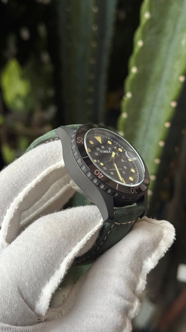 Timex Navi XL Automatic Watch Black Dial Green Strap (Category: Men's Watches) located in Manila. Submitted by junjun12356 (Listing ID 1467575507, Image 3). Description: - Model: Timex Navi XL Automatic Watch - Dial: Black with striking yellow markers and hands - Features: Rotating bezel, date window with a magnifier at 3 o'clock - Case: Dark metal with an exhibition caseback (protective sticker still attached) - Strap: Green leather with contras