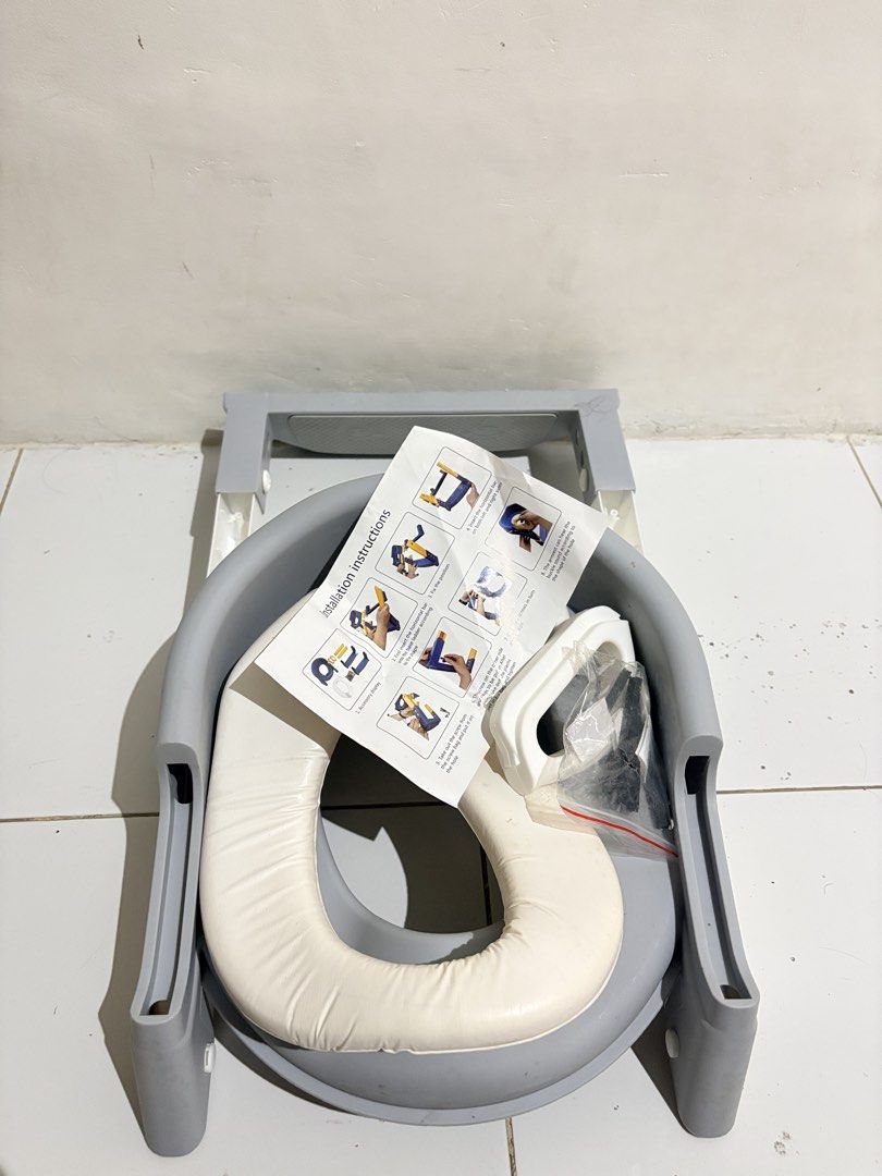 Toddler potty training seat with step stool ladder (Category: Toilet Training) located in General Mariano Alvarez. Submitted by prettyheadtotoe (Listing ID 1467495086, Image 3). Description: - Color: Gray and white - Features a built-in ladder step and comfortable padded white seat cushion - Includes easy-grip handles for extra toddler safety - Complete with instruction sheet and hardware bag with screws - Unassembled parts (easy to set up) - Ide