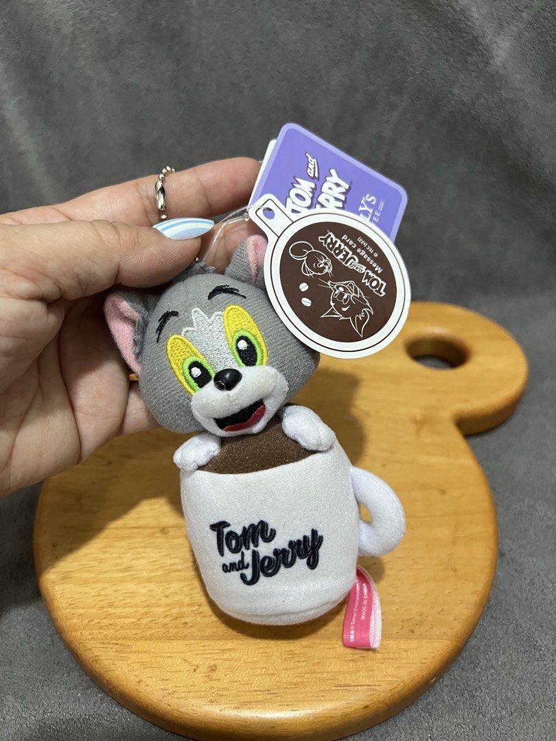 Tom and Jerry Plush Coffee Cup Keychain (Category: Plushies & Soft Toys) located in Las Pinas. Submitted by maple0305 (Listing ID 1467401106, Image 2). Description: - Adorable Tom the cat plush toy tucked inside a white coffee cup - Features an embroidered Tom and Jerry logo on the mug - Comes with a ball chain, perfect for hanging on bags or keys - Includes original brand tags, 100% authentic - Great collectible accessory or gift for fans.