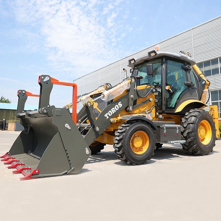 TOROS Backhoe Loader Heavy Construction Machinery (Category: Construction Tools & Equipment) located in Caloocan City. Submitted by xcmgmachinery (Listing ID 1467369523, Image 1). Description: - Brand: TOROS Backhoe Loader - Color: Heavy-duty yellow and dark grey - Tires: Large rubber tires with deep tread patterns for maximum grip - Bucket: Multi-function front bucket equipped with red teeth attachments - Cab: Enclosed glass cab complete with ro
