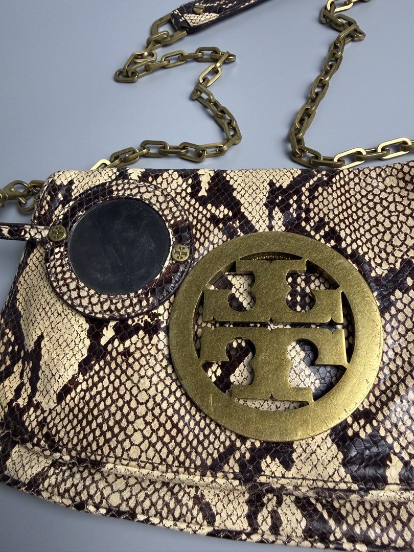 Tory Burch Audra Reva Shoulder Bag (Category: Luxury Bags & Wallets) located in Manila. Submitted by limsanity03 (Listing ID 1467488642, Image 3). Description: - Brand: Tory Burch - Material: Python print leather in neutral cream and brown - Hardware: Antique brass with signature T logo on front flap - Strap: Chain and leather shoulder strap - Inclusion: Matching round pouch - Interior: Fabric lining with zip pocket and branded metal pull - Condi