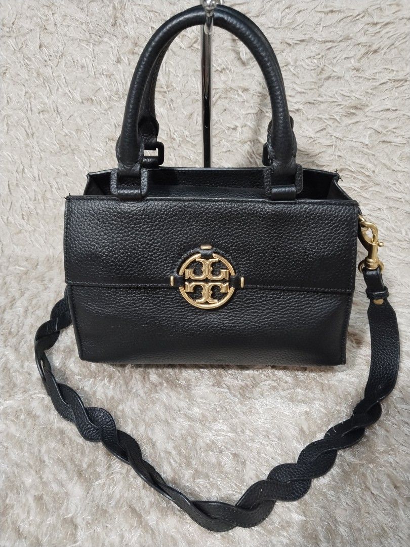 Tory Burch Black Leather Handbag (Category: Luxury Bags & Wallets) located in Caloocan City. Submitted by jezel07 (Listing ID 1467548203, Image 1). Description: - Brand: Tory Burch - Material: Premium black pebbled leather - Hardware: Elegant gold-tone hardware - Straps: Dual top handles and a chic braided shoulder strap - Closure: Secure top-zip closure - Interior: Clean dark lining with one zippered pocket - Structure: Maintains its shape nicel
