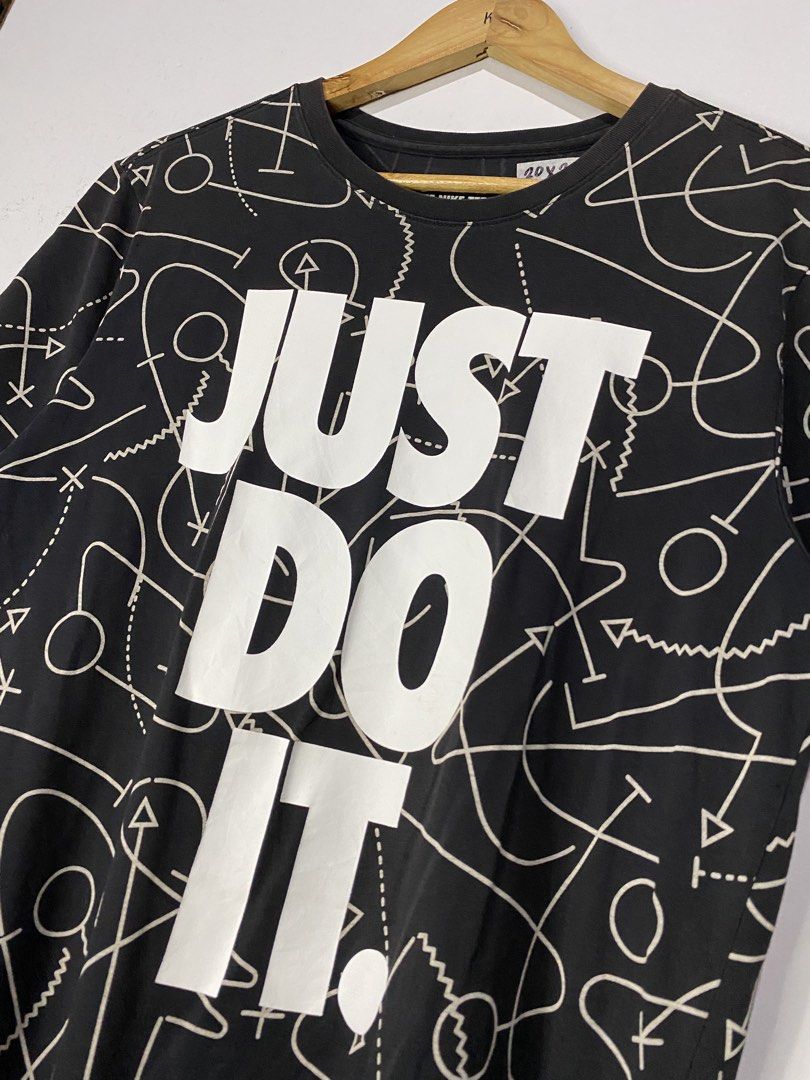 TSHIRT (Category: Tshirts & Polo Shirts ) located in Jaen. Submitted by oshimamark58418 (Listing ID 1467521123, Image 3). Description: - Brand: Nike - Design: Black tee with white "Just Do It" front logo and all-over abstract playbook/doodle graphics - Fabric: Dri-Fit material for breathable, athletic wear - Size: Tagged Size L (Athletic Cut) with actual flat measurements of 20x26 inches, fits like a Medium - Condition: 7/10 pre-loved condition -