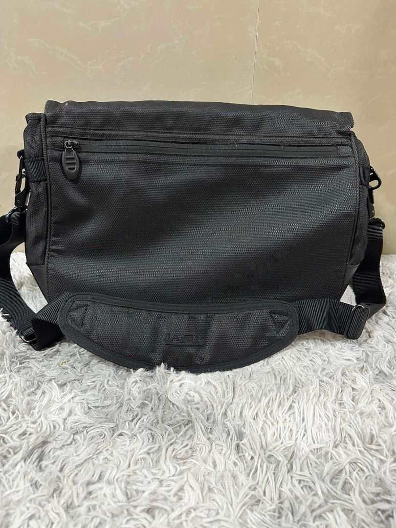 Tumi Black Messenger Bag (Category: Sling Bags) located in Dipolog. Submitted by adrian281994 (Listing ID 1467387238, Image 2). Description: - Brand: Tumi - Color: Classic Black - Material: Sturdy, durable nylon fabric - Comfort: Adjustable shoulder strap with padded shoulder pad - Closure: Front flap with Tumi logo badge and red lettering - Organization: Multiple interior and exterior zip pockets - Authenticity: Features signature patterned lini