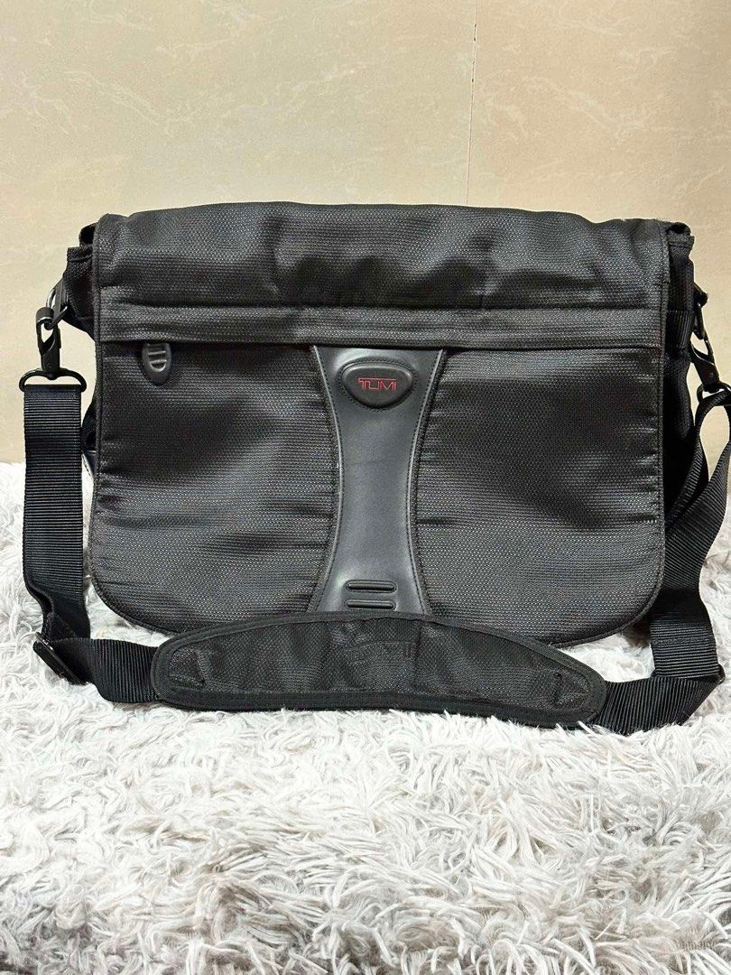 Tumi Black Messenger Bag (Category: Sling Bags) located in Dipolog. Submitted by adrian281994 (Listing ID 1467387238, Image 3). Description: - Brand: Tumi - Color: Classic Black - Material: Sturdy, durable nylon fabric - Comfort: Adjustable shoulder strap with padded shoulder pad - Closure: Front flap with Tumi logo badge and red lettering - Organization: Multiple interior and exterior zip pockets - Authenticity: Features signature patterned lini