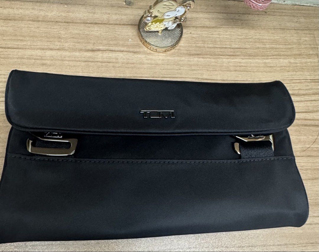 TUMI Black Travel Toiletry Bag Makeup Pouch (Category: Purses & Pouches) located in Manila. Submitted by xenasales (Listing ID 1467373362, Image 1). Description: - Authentic Tumi toiletry bag in sleek black with stylish silver-tone hardware - Secure fold-over flap closure featuring classic buckle details - Spacious interior with Tumi monogram grey lining - Stay organized with multiple compartments, a zippered pocket, and a clear plastic pouch sec