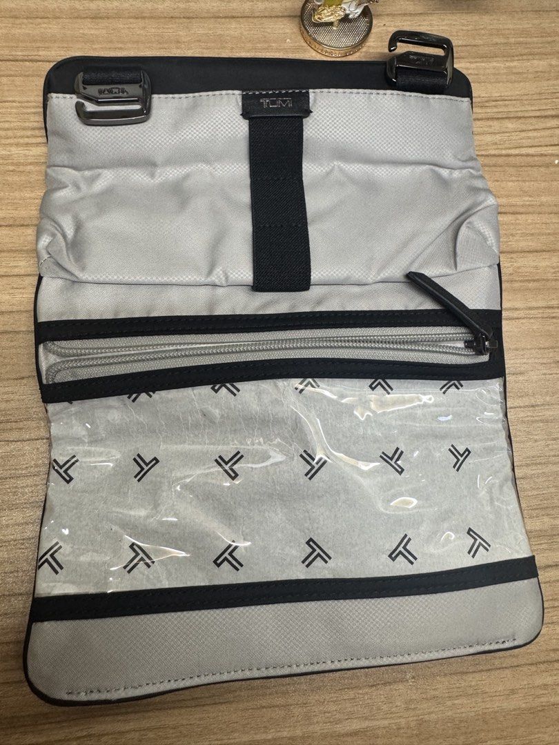 TUMI Black Travel Toiletry Bag Makeup Pouch (Category: Purses & Pouches) located in Manila. Submitted by xenasales (Listing ID 1467373362, Image 2). Description: - Authentic Tumi toiletry bag in sleek black with stylish silver-tone hardware - Secure fold-over flap closure featuring classic buckle details - Spacious interior with Tumi monogram grey lining - Stay organized with multiple compartments, a zippered pocket, and a clear plastic pouch sec