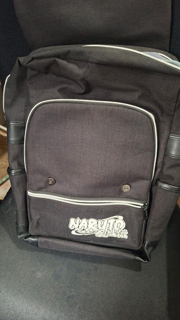 Uchiha Clan Black Backpack Anime Bag (Category: Backpacks) located in Marikina City. Submitted by makimki (Listing ID 1467400518, Image 3). Description: - Design: Black canvas Naruto backpack featuring the red and white Uchiha crest and Japanese text on the front flap, plus the official Naruto logo on the lower right. - Storage: Roomy main compartment with grey fabric lining and a secure zippered inner pocket for your small essentials. - Pockets 