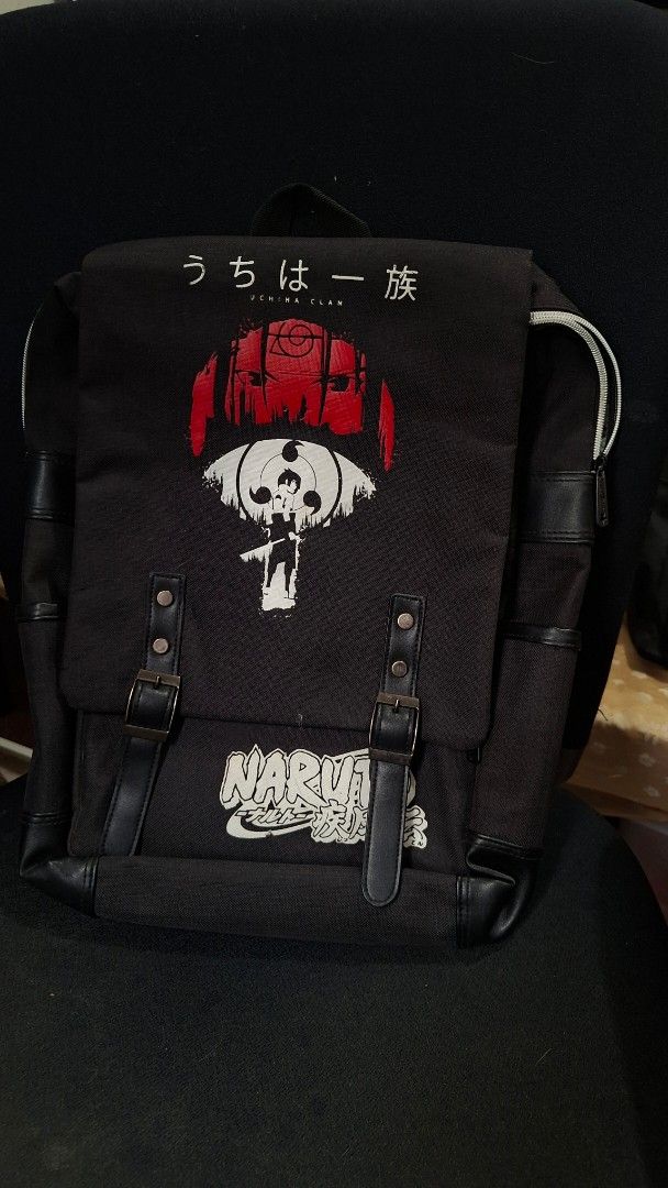 Uchiha Clan Black Backpack Anime Bag (Category: Backpacks) located in Marikina City. Submitted by makimki (Listing ID 1467400518, Image 1). Description: - Design: Black canvas Naruto backpack featuring the red and white Uchiha crest and Japanese text on the front flap, plus the official Naruto logo on the lower right. - Storage: Roomy main compartment with grey fabric lining and a secure zippered inner pocket for your small essentials. - Pockets 
