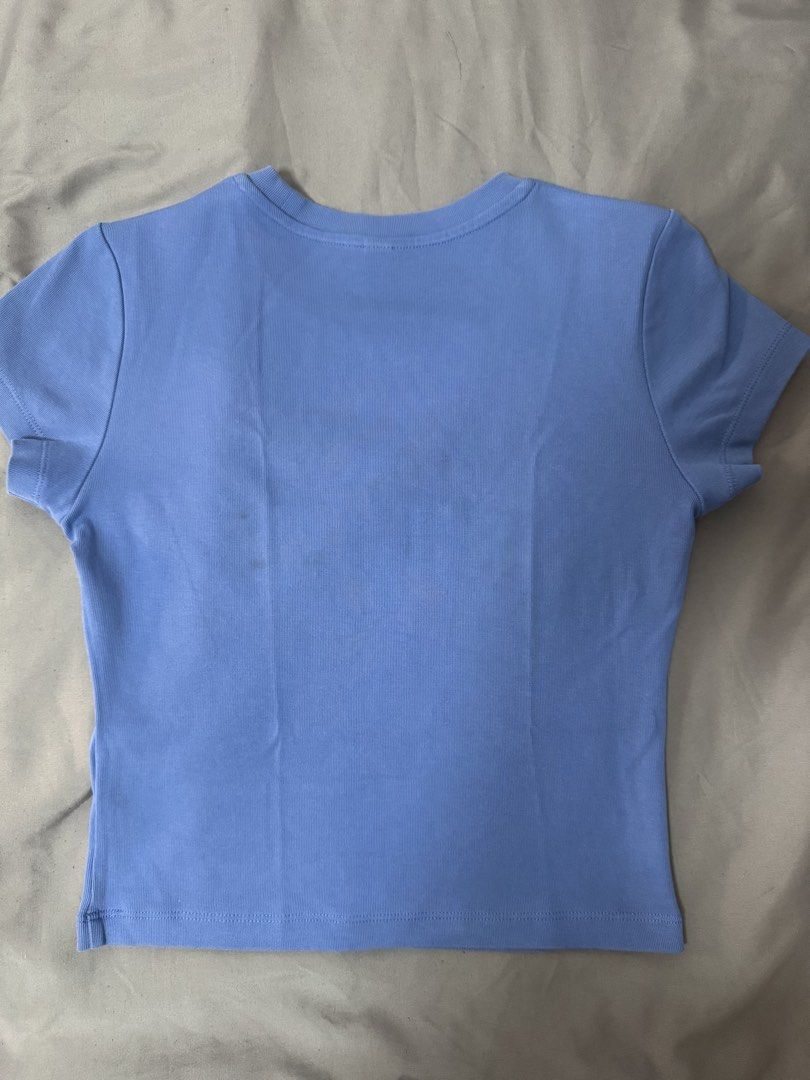 Uniqlo Blue Crop Top Size S (Category: Shirts) located in Quezon City. Submitted by mikhaela.b (Listing ID 1467552516, Image 2). Description: - Brand: Uniqlo - Color: Baby blue - Size: S - Material: Stretchy cotton - Origin: Made in Vietnam - Design: Short sleeves, classic crew neck fit - Condition: Good, with a few faint dark spots on the back and near the underarm seam.
