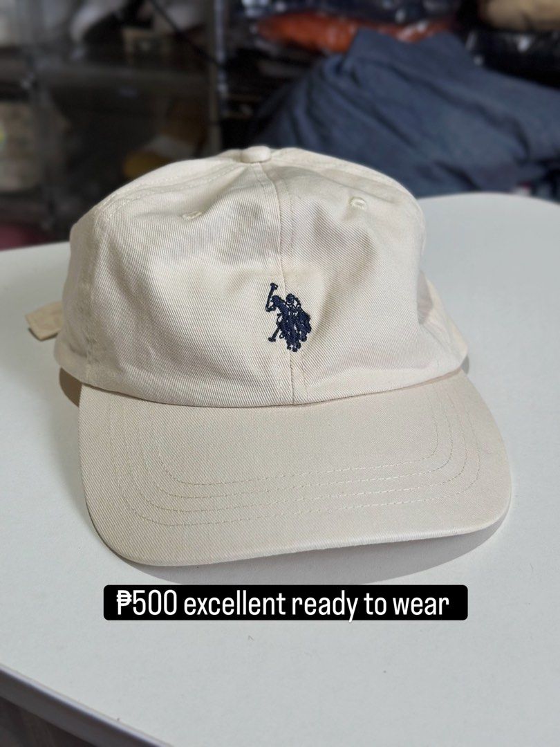 USPA Beige Baseball Cap with Navy Blue Embroidery (Category: Caps & Hats) located in Daet. Submitted by thrifthings2018 (Listing ID 1467446579, Image 1). Description: - Brand: USPA (United States Polo Association) - Color: Cream / Beige canvas - Design: Dark blue polo player embroidery on the front, USPA spelled out on the back - Fit: Classic six-panel structure with ventilation eyelets and adjustable strap with brass clasp - Condition: Clean, fr