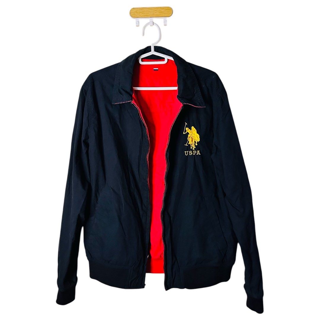 USPA Black Jacket with Red Lining (Reversible) (Category: Coats, Jackets and Outerwear) located in Pasay City. Submitted by eufro.solevilla17 (Listing ID 1467530352, Image 1). Description: - Brand: USPA (US Polo Assn.) - Color: Classic black with bold red inner lining - Design: Large yellow embroidered logo on the chest - Fit & Features: Standard collar, full zip-up closure, ribbed hem and cuffs - Style: Bomber jacket, perfect outer layer for coo