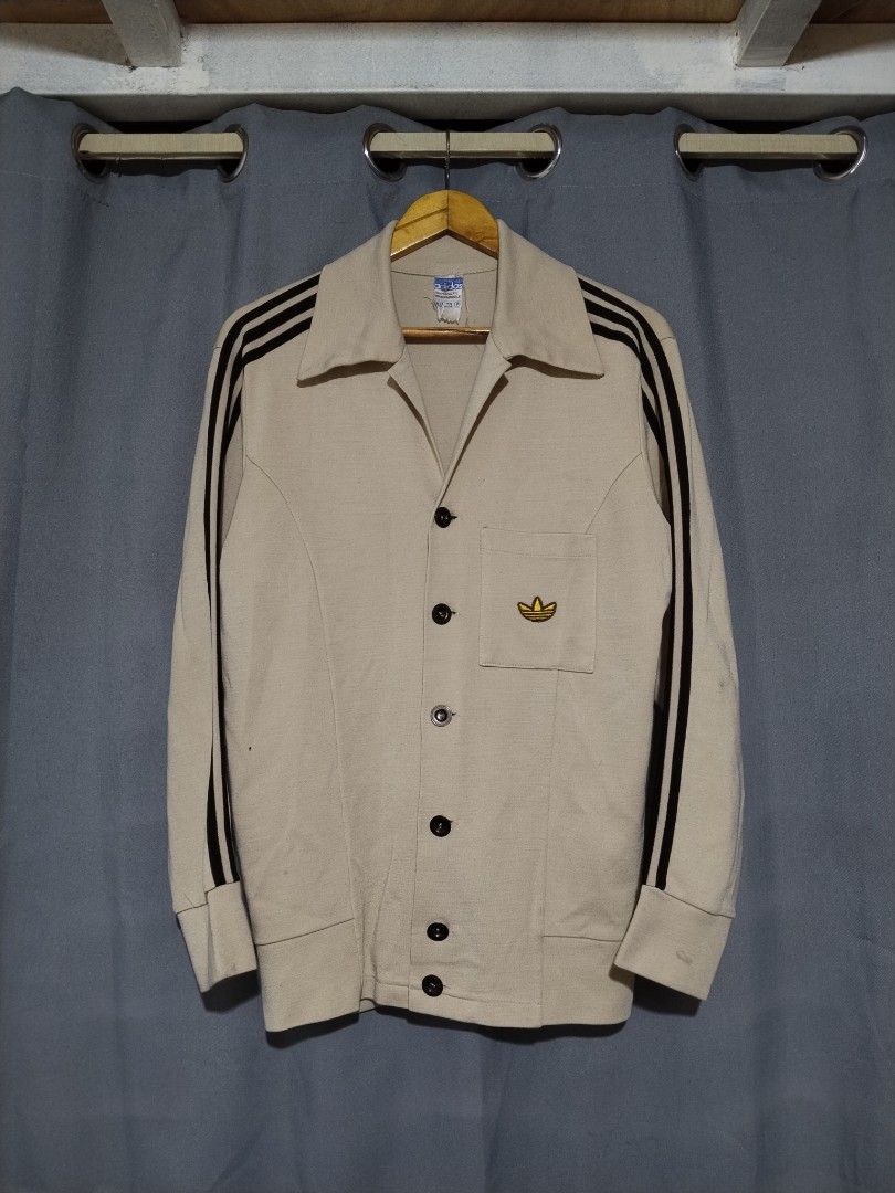 Vintage 70s Adidas Schwan Metal Button Jacket (Category: Coats, Jackets and Outerwear) located in Pasig City. Submitted by loveforlux_2025 (Listing ID 1467408771, Image 1). Description: - Brand: Adidas - rare find - Style: Vintage cardigan with dark stripes on sleeves - Color: Beige - Details: Classic pointed lapel collar, button-up front, single chest pocket with embroidered gold trefoil logo, adjustable button cuffs - Condition: Retro piece wit