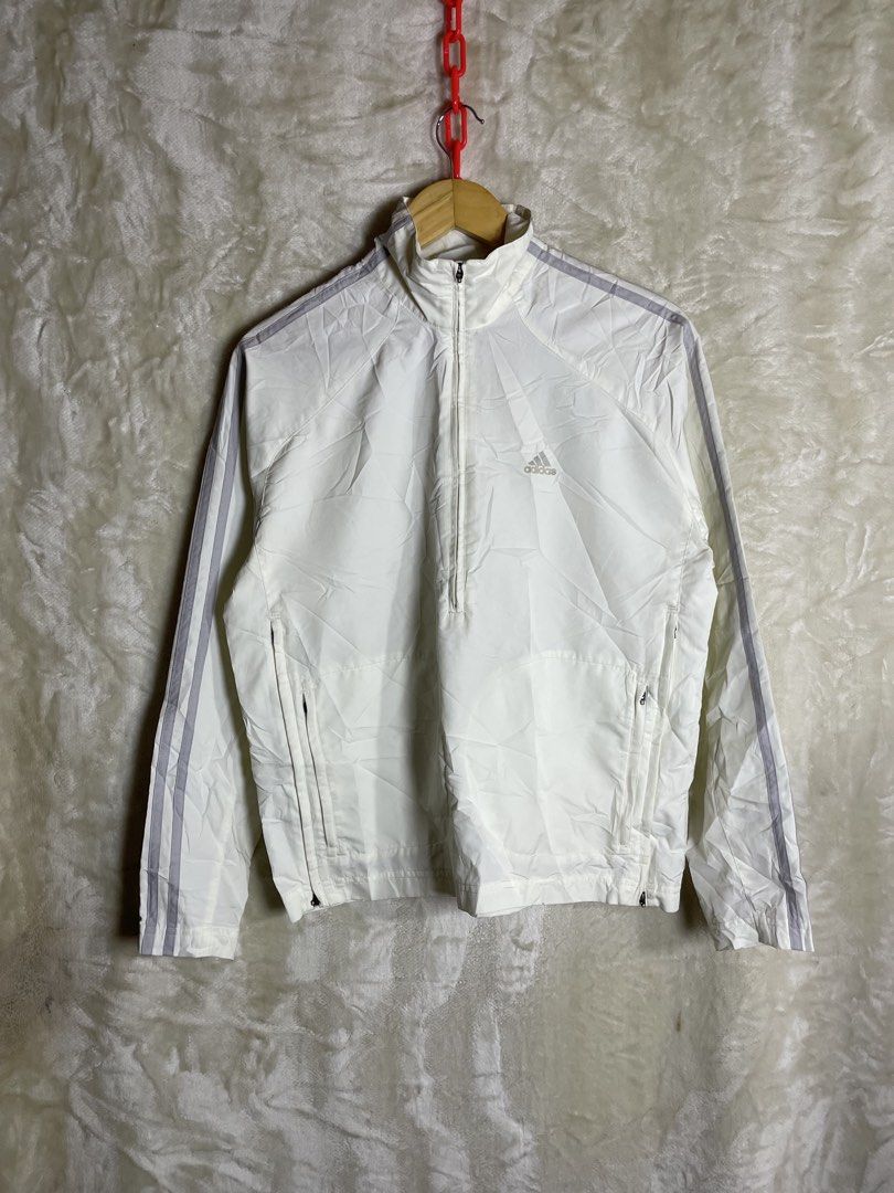 Vintage Adidas White Track Jacket Windbreaker (Category: Coats, Jackets and Outerwear) located in Molave. Submitted by charlesthrifter (Listing ID 1467366586, Image 1). Description: - Color: Clean white with iconic grey stripes down both sleeves - Design: High collar, half-zip front closure, and dual zipper waist pockets - Material: Lightweight and comfortable, perfect for workouts or casual streetwear - Authenticity: Features the classic blue Ad