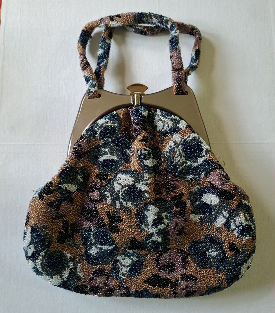 Vintage Beaded Floral Handbag with Structured Handle (Category: Shoulder Bags) located in Don Carlos. Submitted by PphiXi_Finds (Listing ID 1467438637, Image 1). Description: - Vintage beaded handbag with a stunning multicolored floral glass bead pattern (bronze, blue, white, purple) - Structured metallic frame handle with a secure top clasp closure - Clean cream satin fabric lining on the inside with convenient slip pockets - Compact size measur