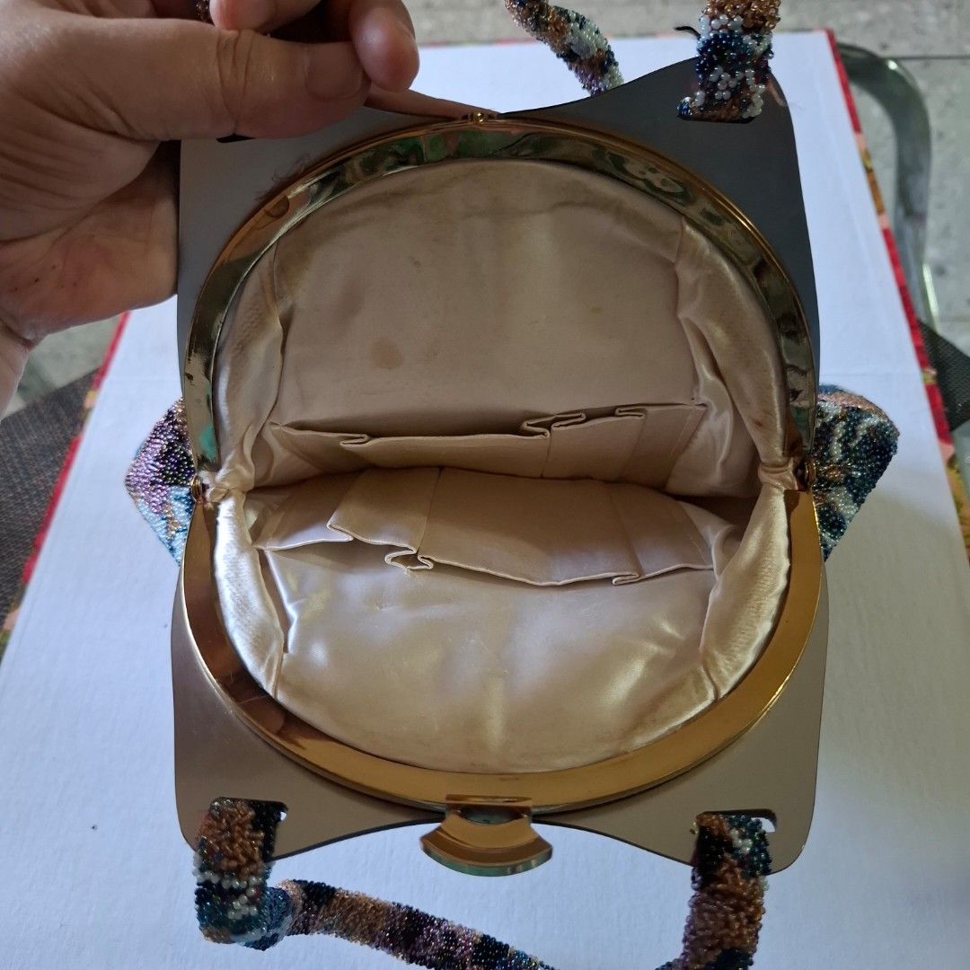 Vintage Beaded Floral Handbag with Structured Handle (Category: Shoulder Bags) located in Don Carlos. Submitted by PphiXi_Finds (Listing ID 1467438637, Image 2). Description: - Vintage beaded handbag with a stunning multicolored floral glass bead pattern (bronze, blue, white, purple) - Structured metallic frame handle with a secure top clasp closure - Clean cream satin fabric lining on the inside with convenient slip pockets - Compact size measur
