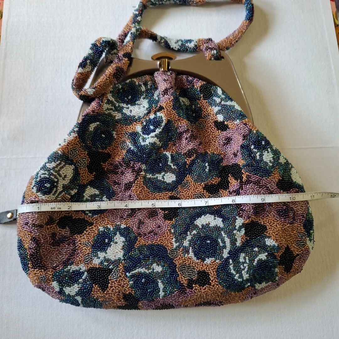 Vintage Beaded Floral Handbag with Structured Handle (Category: Shoulder Bags) located in Don Carlos. Submitted by PphiXi_Finds (Listing ID 1467438637, Image 3). Description: - Vintage beaded handbag with a stunning multicolored floral glass bead pattern (bronze, blue, white, purple) - Structured metallic frame handle with a secure top clasp closure - Clean cream satin fabric lining on the inside with convenient slip pockets - Compact size measur